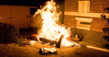 Brandweer blust brandende bank bij bebouwing Busschieterstraat