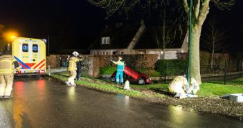 Vrouw met auto te water langs de Lage Giessen in Hoornaar