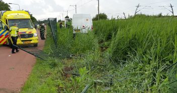Bestuurder bedrijfsbus wordt onwel en rijdt door hek in Sliedrecht