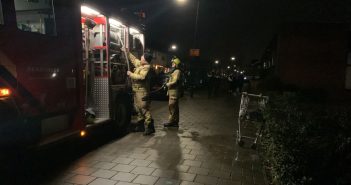 Winkelwagen met kranten in brand in trappenhuis