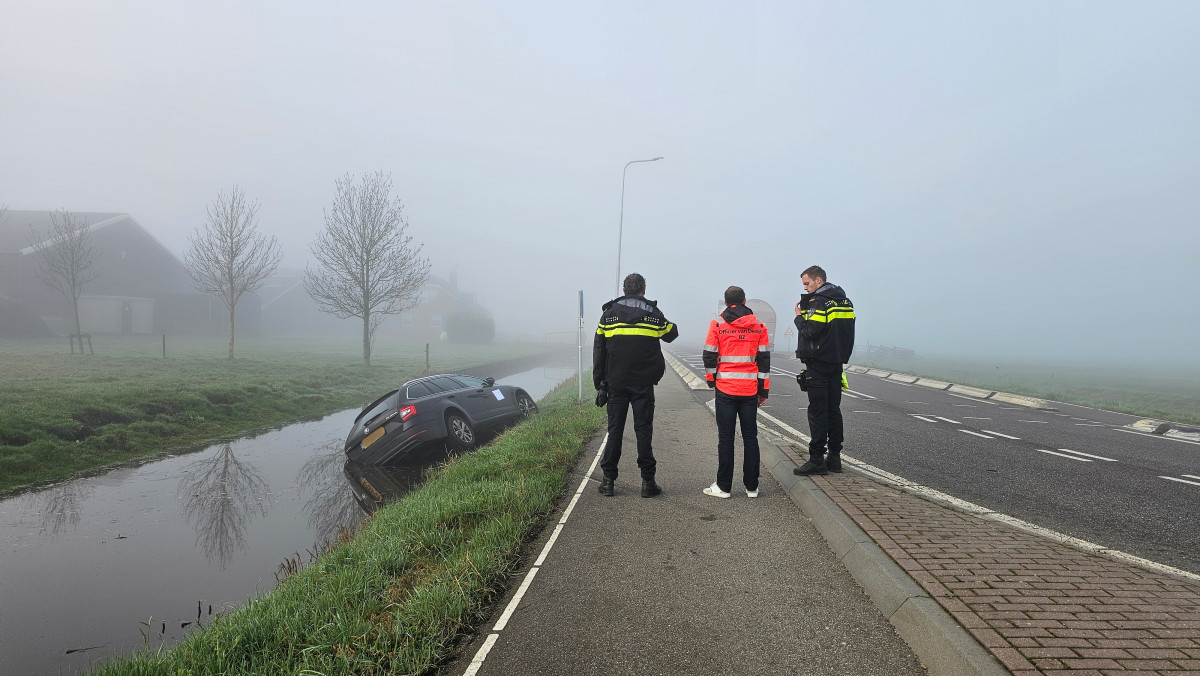 Auto raakt te water langs Middenpolderweg bij Streefkerk