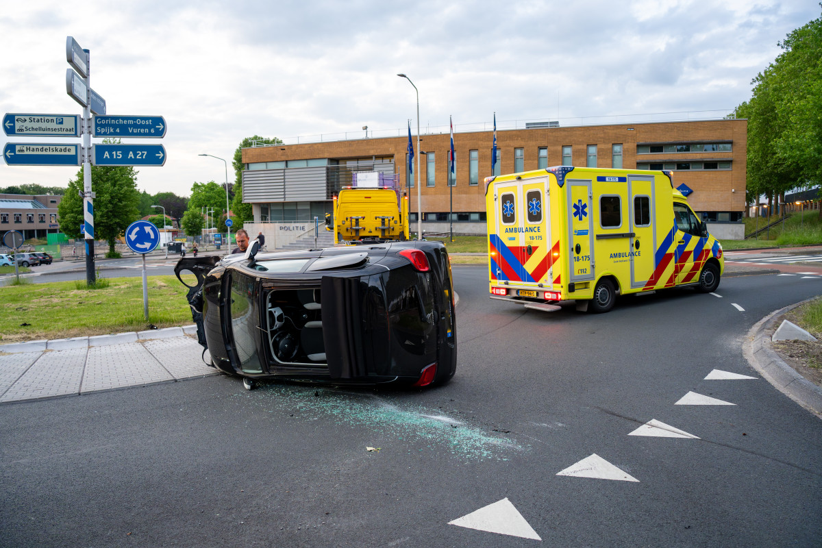 Auto op zijn kant op rotonde in Gorinchem